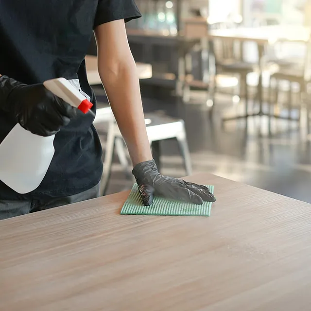 Hombre limpiando mesa de negocio