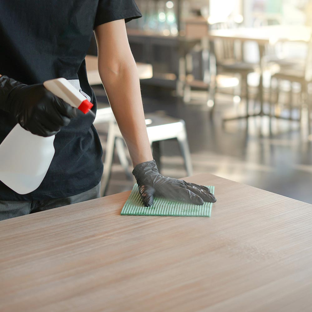 Hombre limpiando mesa de negocio